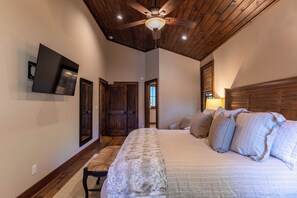 A bedroom with a large bed, wooden ceiling, and a ceiling fan. - One Sweet Getaway at Eagles Nest (Banner Elk)