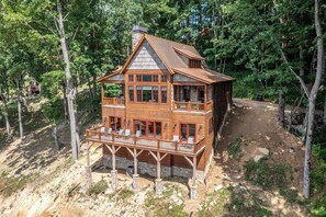 Eine Holzhütte mit einem Balkon, umgeben von Bäumen.