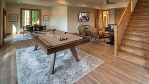 A spacious room with a pool table, a comfortable seating area, and a staircase. - Mountain Vistas at Eagles Nest (Banner Elk)