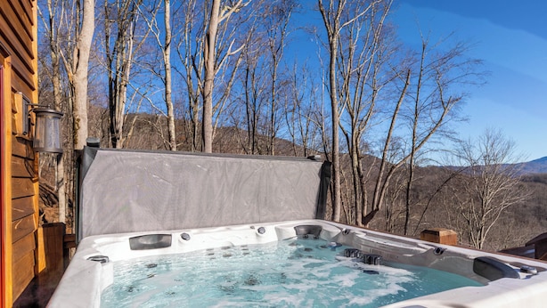 A hot tub with a view of trees and mountains. - Mountain Vistas at Eagles Nest (Banner Elk)