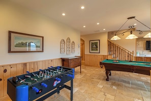 A room with a foosball table, a pool table, wooden paneling, and framed pictures on the walls. - Buena Vista (Fleetwood)