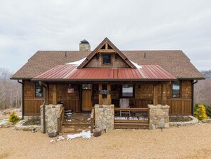 A rustic lodge with a stone chimney, wooden exterior, and a metal roof. - True Blue 92 at Eagles Nest (Banner Elk)