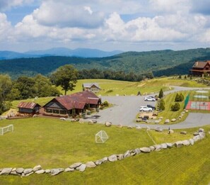 A rural property with a main building, a guesthouse, a parking area, and a view of distant mountains. - True Blue 92 at Eagles Nest (Banner Elk)
