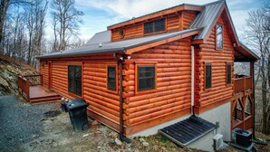A log cabin with a steep roof, a front porch, and a small deck. - High Time Cabin (Banner Elk)