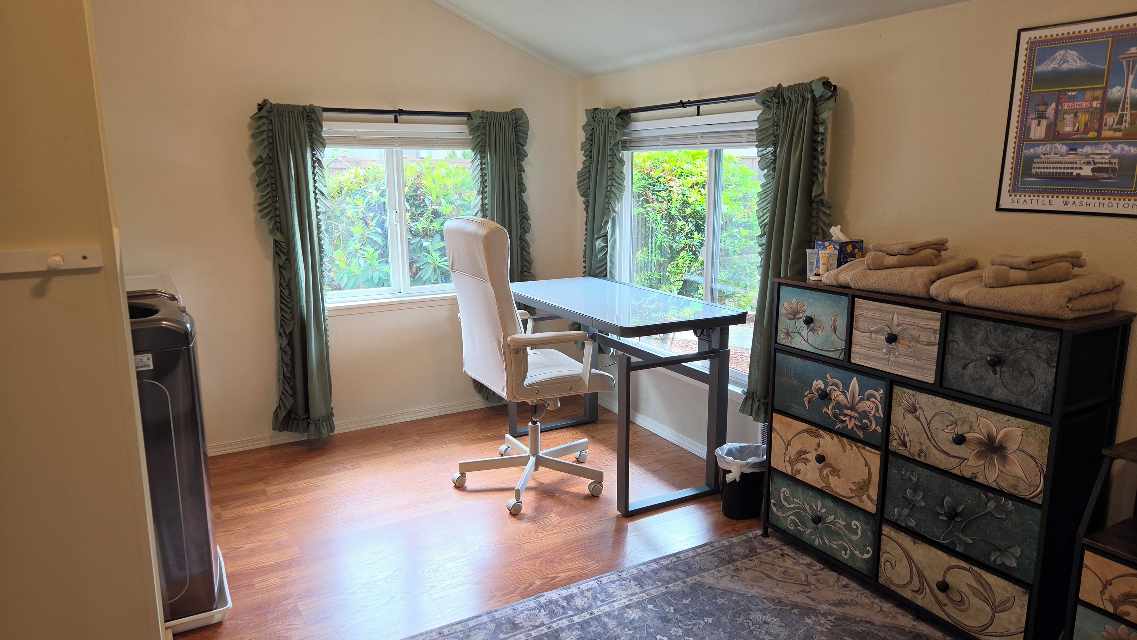 A room with a desk, chair, and a dresser with drawers.