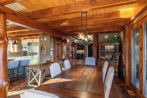 A rustic wooden interior with a dining area, kitchen, and bar. - Bailey's Creek Lodge (Hudson)