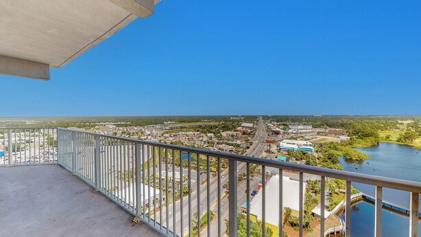 A balcony with a view of a town, a road, and a body of water. - Laketown Wharf 1738 (Panama City Beach)