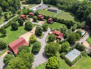 An aerial view of a residential area with multiple houses, a cemetery, and a swimming pool. - Moonlight View at Eagles Nest (Banner Elk)