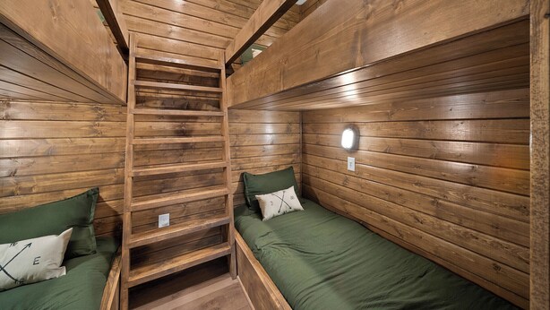 A wooden cabin interior with two bunk beds, a ladder, and a small shelf. - Boulder Springs Lodge at Eagles Nest (Banner Elk)