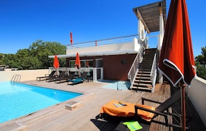 A poolside area with lounge chairs, umbrellas, and a staircase leading to an upper deck. -  Escapade à Antibes avec Piscine Rooftop (Antibes)