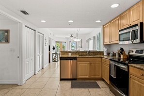 A modern kitchen with wooden cabinets, stainless steel appliances, and a granite countertop.