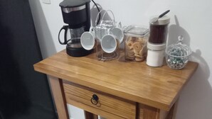 A wooden desk with a coffee maker, cups, a jar, and a glass. - Suite with kitchen, well located. (Barra Velha)