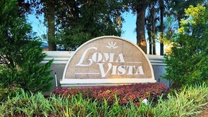 Un letrero con la inscripción 'Loma Vista', rodeado de follaje.