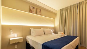 Ein Hotelzimmer mit Bett, Nachttisch und Wandleuchte.