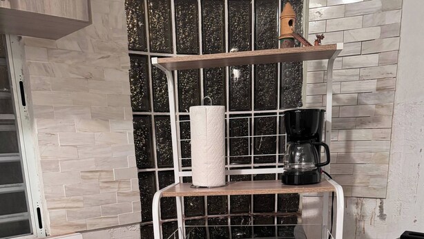A kitchen with a microwave, coffee maker, and a stainless steel oven.