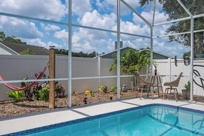 A backyard with a swimming pool, a hammock, and outdoor furniture. - 3BR Home with Private Pool Minutes from Disney (Kissimmee)