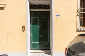 Eine grüne Tür mit einem Schild mit der Aufschrift '10', das den Eingang zu einem Gebäude kennzeichnet.