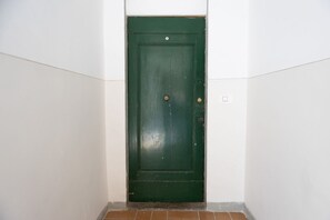 Eine grüne Tür mit Messinggriffen und einer kleinen Messingschild über der Tür.
