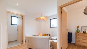 A modern bedroom with a bed, bedside table, lamp, and a dresser. - Architect-designed house 800m from the sea (Paimpol)