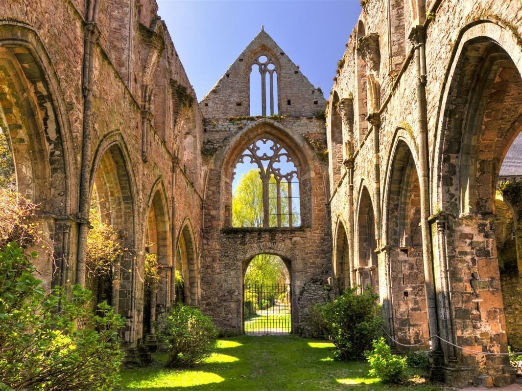 An ancient stone structure with arched doorways and a central window.