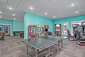 A recreational area with a ping pong table, arcade games, and seating. - Spacious 3-bedroom apartment in beautiful Branson with AC and gym (Branson)