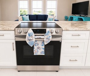 A kitchen with a stainless steel oven, a digital clock, and a patterned towel tied around the oven door. - Tu hogar lejos de Casa..4BR..POOL ..PET Friendly ! (Port Charlotte)