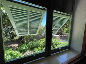A window with a view of a garden and a wooden fence. - Casa Magnogia-sotto, cozy apartment with a garden; dogs welcome (Imperia)