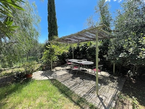 A patio area with a pergola, stone wall, and potted plants. - Casa Magnogia-sotto, cozy apartment with a garden; dogs welcome (Imperia)
