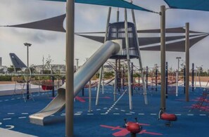 A playground with a slide, climbing structures, and a shaded area. - 2 min from Finance City + Fiber + 110 m² + Free Parking + PS4 + IPTV (Casablanca)