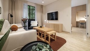 A modern living room with a sofa, a coffee table, a TV mounted on the wall, and a dining area with a table and chairs. - CAM 1-Bedroom Deluxe (Ciudad de México)