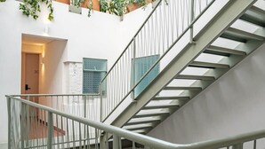 A modern staircase with metal railings and a white wall. - CAM 1-Bedroom Deluxe (Ciudad de México)