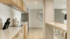 A modern kitchen with wooden cabinets, a stainless steel sink, and a countertop with a knife block. - Modern King Studio in Central Roma Norte (Ciudad de México)