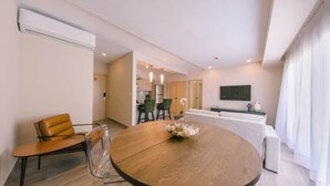 A modern living room with a round wooden table, a sofa, and a TV. - Regatta Living Ii with Breakfast Included! - 905 (Santo Domingo)