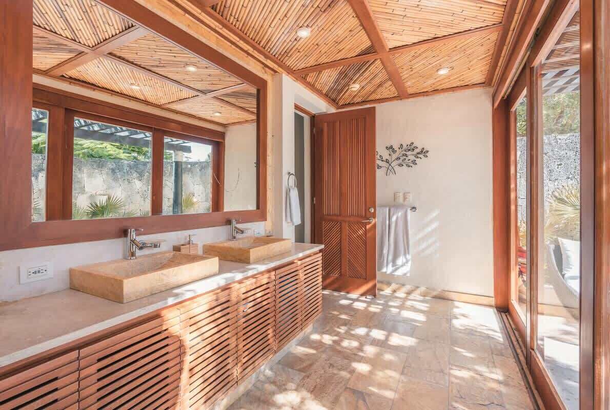 Un bagno moderno con un mobile bagno in legno, uno specchio grande e uno spazio doccia.