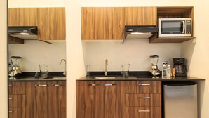 A compact kitchen with wooden cabinets, a built-in microwave, a blender, and a coffee maker. - Private Suite with Incredible View & Pool (Guadalajara)