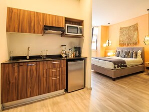 A compact kitchen with wooden cabinets, a built-in microwave, and a compact refrigerator. - Private Suite with Incredible View & Pool (Guadalajara)