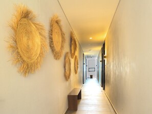 A hallway with a bench, decorative wall art, and a light fixture. - Private Suite with Incredible View & Pool (Guadalajara)