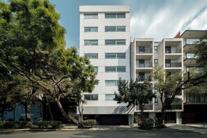 Ein modernes, mehrgeschossiges Gebäude mit flacher Fassade, großen Fenstern und Balkonen.