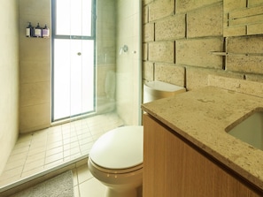A bathroom with a shower, toilet, and a sink with a countertop. - Spacious Stylish Loft w Gym (Guadalajara)