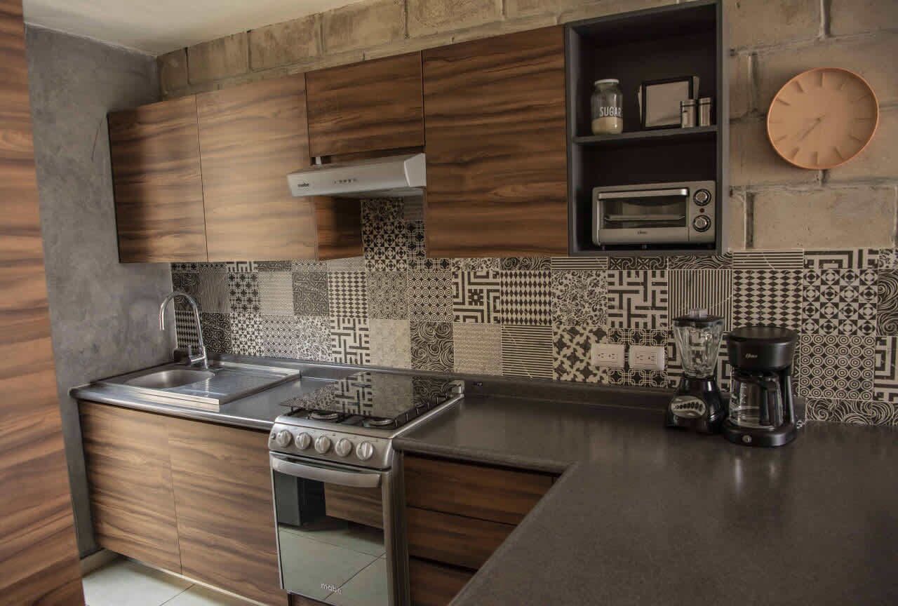 A modern kitchen with wooden cabinets, a gas stove, a built-in oven, a microwave, and a coffee maker.