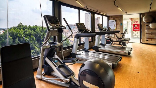 Ein Fitnessstudio mit Laufbändern, Crosstrainern und Rudergeräten.