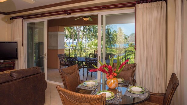 A dining area with a glass table, chairs, and a view of palm trees. - Bay Residence 7C -  3 bdr 2 bath (Playa Herradura)