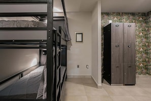 Ein Schlafraum mit Etagenbett, einem Kleiderschrank und einem gerahmten Bild an der Wand.