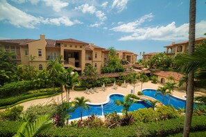 A resort with multiple buildings, a swimming pool, and palm trees. - Bella Vista 2D 3 bdr  3 1 and half bath (Playa Herradura)