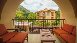 A balcony with a view of a large house, a table, and two sofas. - Bella Vista 2D 3 bdr 3 1 and half bath (Playa Herradura)