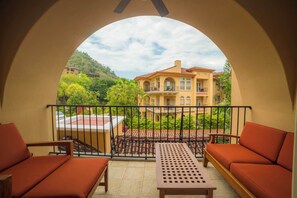 A balcony with a view of a large house, a table, and two sofas. - Bella Vista 2D 3 bdr  3 1 and half bath (Playa Herradura)