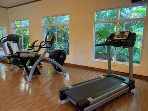 A gym with cardio equipment, large windows, and a wooden floor. - Veranda 3G 2 bedr 2 bath (Playa Herradura)