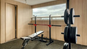Et træningscenter med bænkpres, squat-ställ og vægtskiver.
