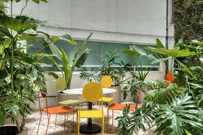 A room with a round table, yellow chairs, and green plants. - Modern King Studio in Central Roma Norte (Ciudad de México)