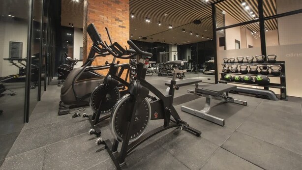 Una palestra con cyclette, macchinari per pesi e una panca.